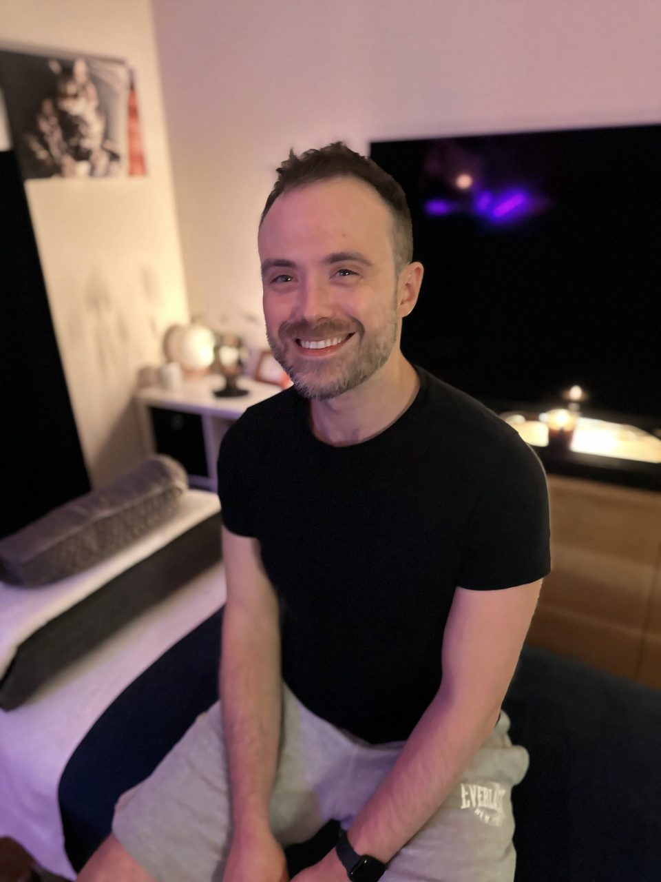 Jordan, massage therapist at Aligned Bodywork, smiling in the studio